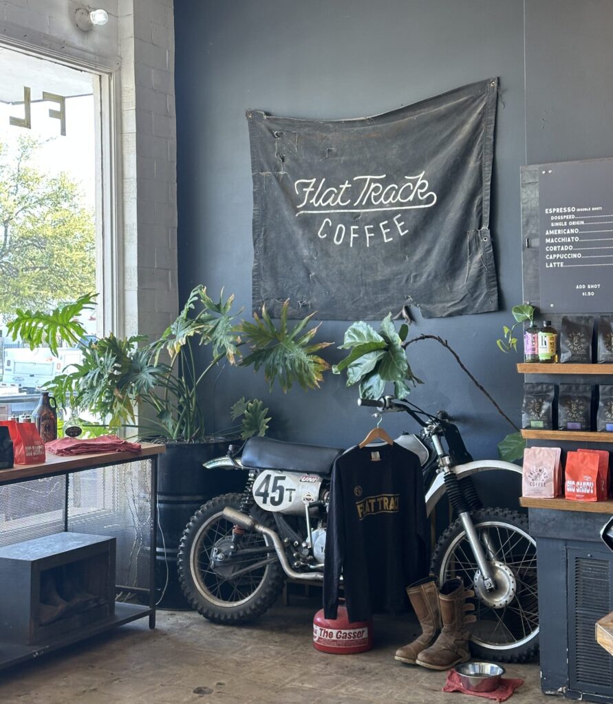 Inside Flat Truck Coffee in Austin Texas by the window with potted plants and merch for sale