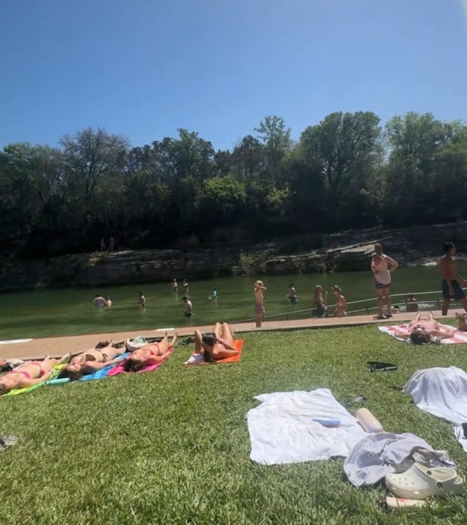 People laying on the grass at Barton Springs Pool
